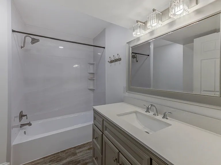 Freshly cleaned bathroom vanity, mirror, and tub