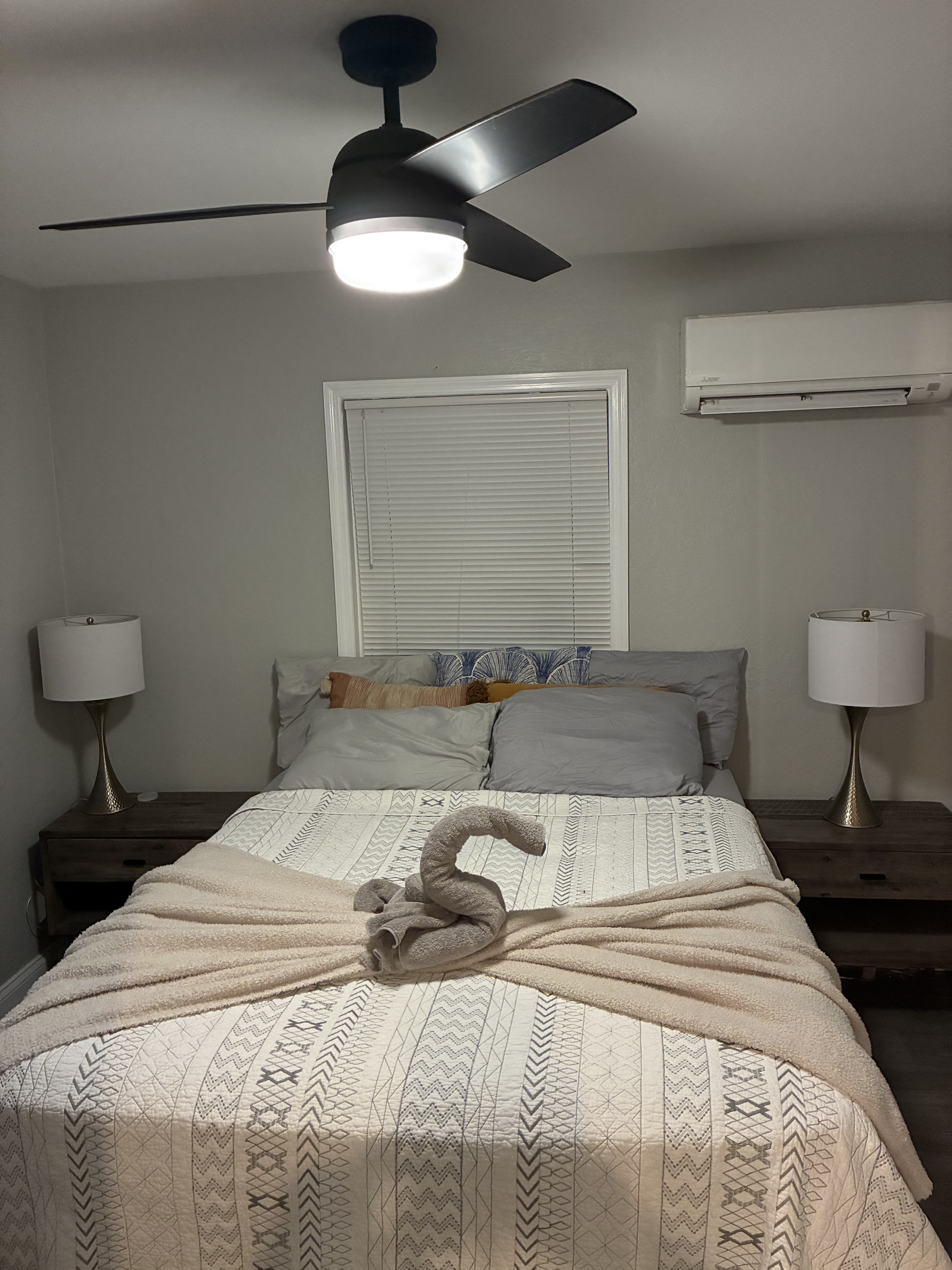 Clean bedroom with arranged bed, folded blanket, and towel detail