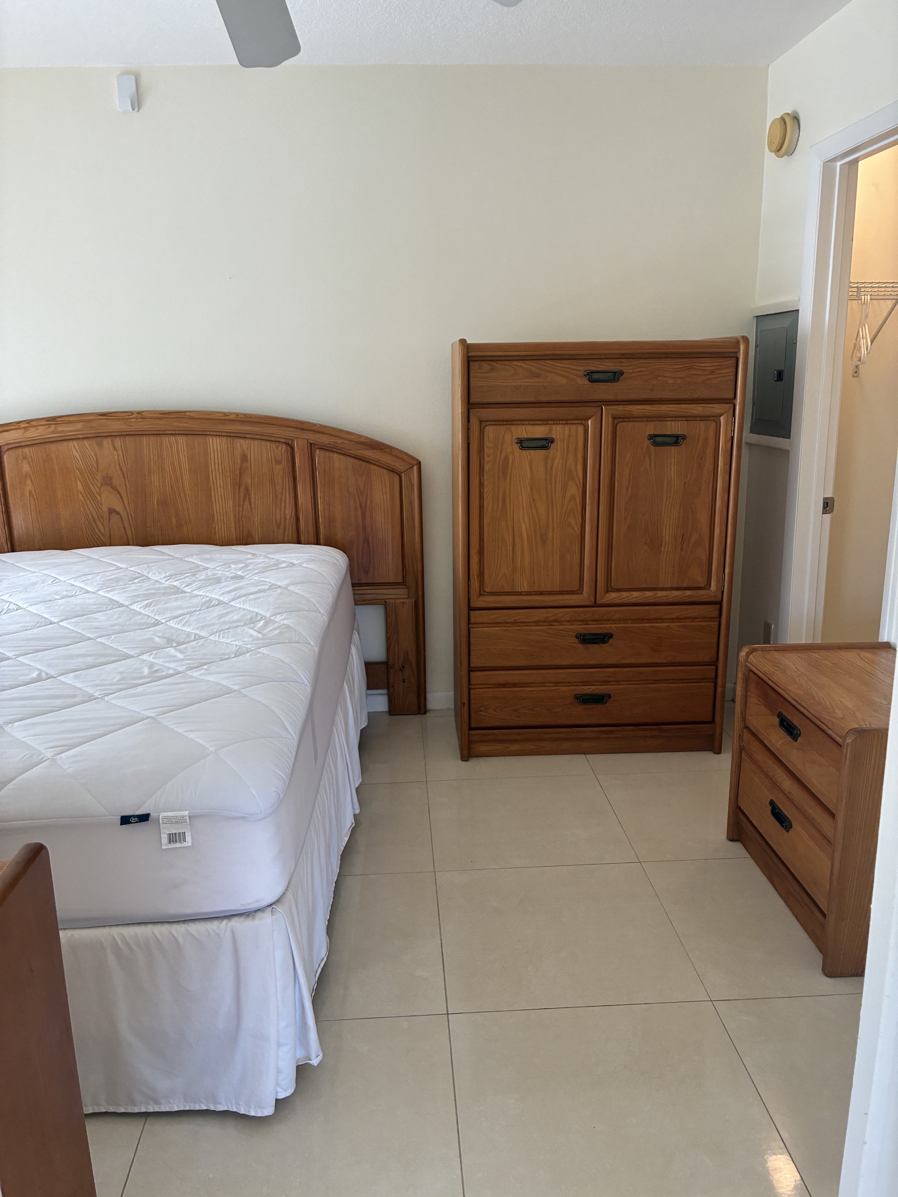 Clean bedroom furniture, bed, and tile flooring