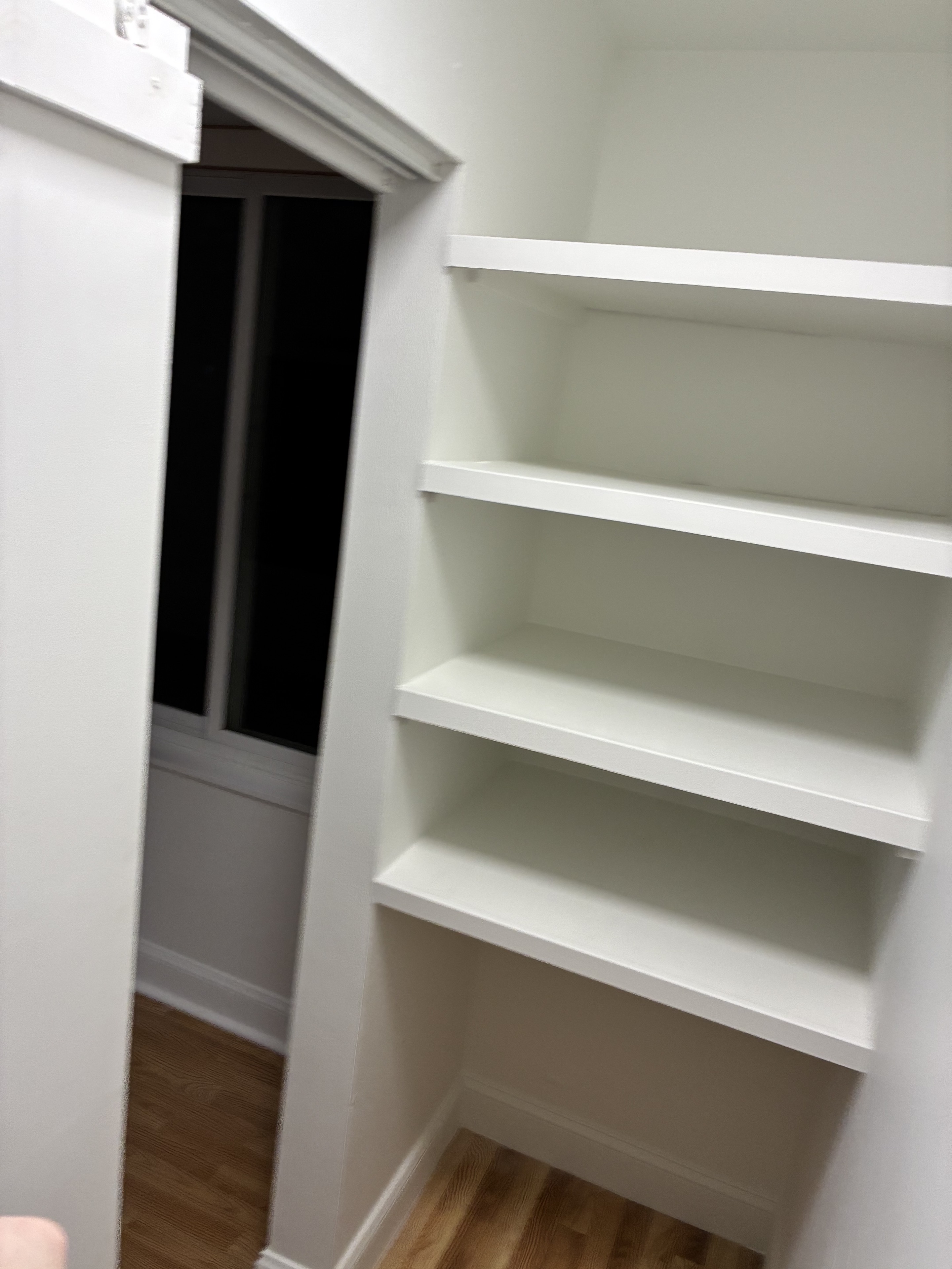 Clean built-in shelving and trim near a hardwood floor room