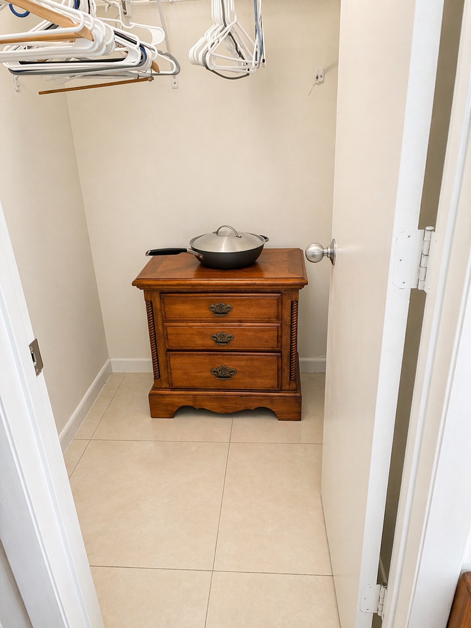 Clean closet with tile floor and organized hangers