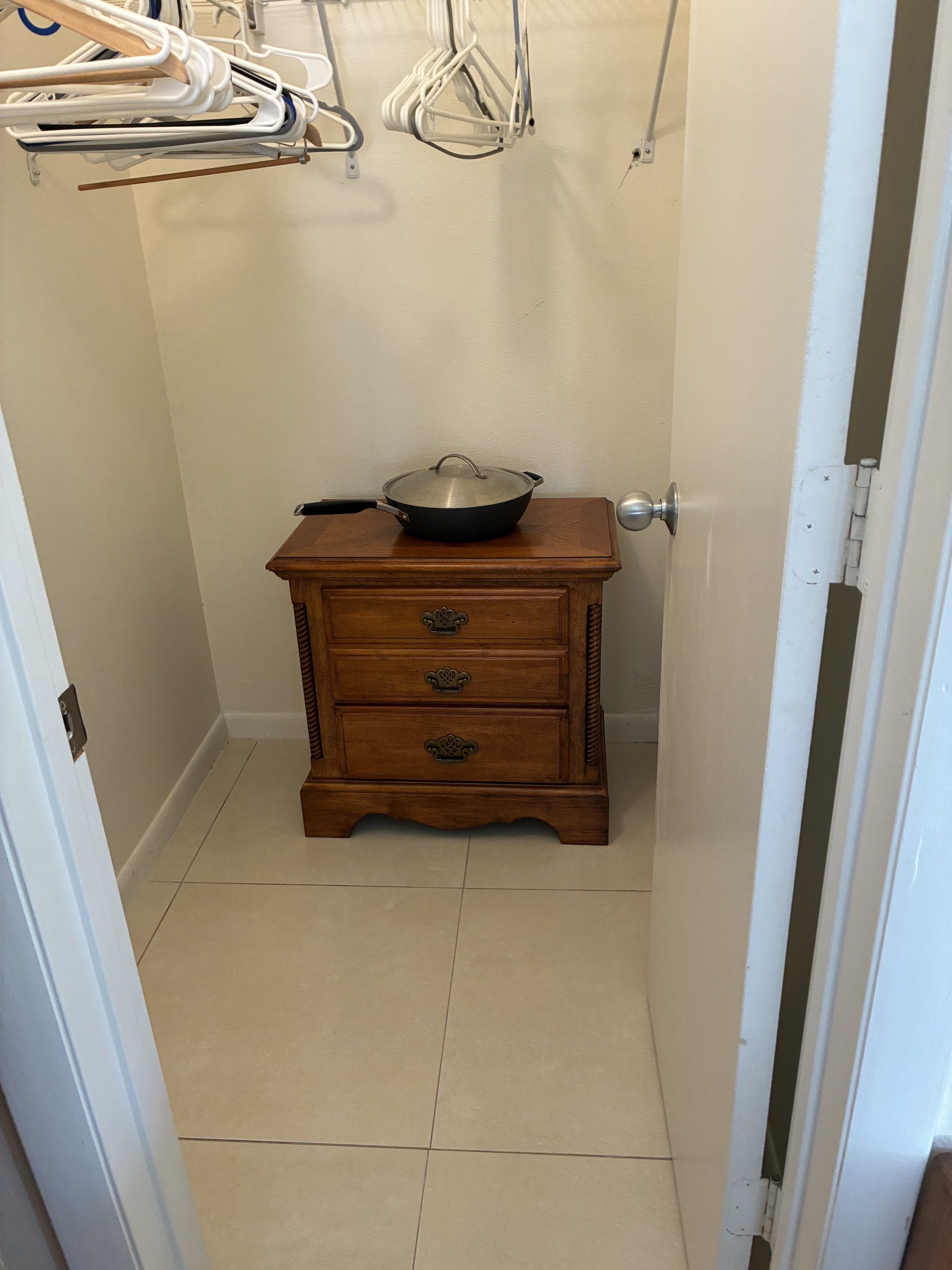 Clean closet area with dresser and tile floor
