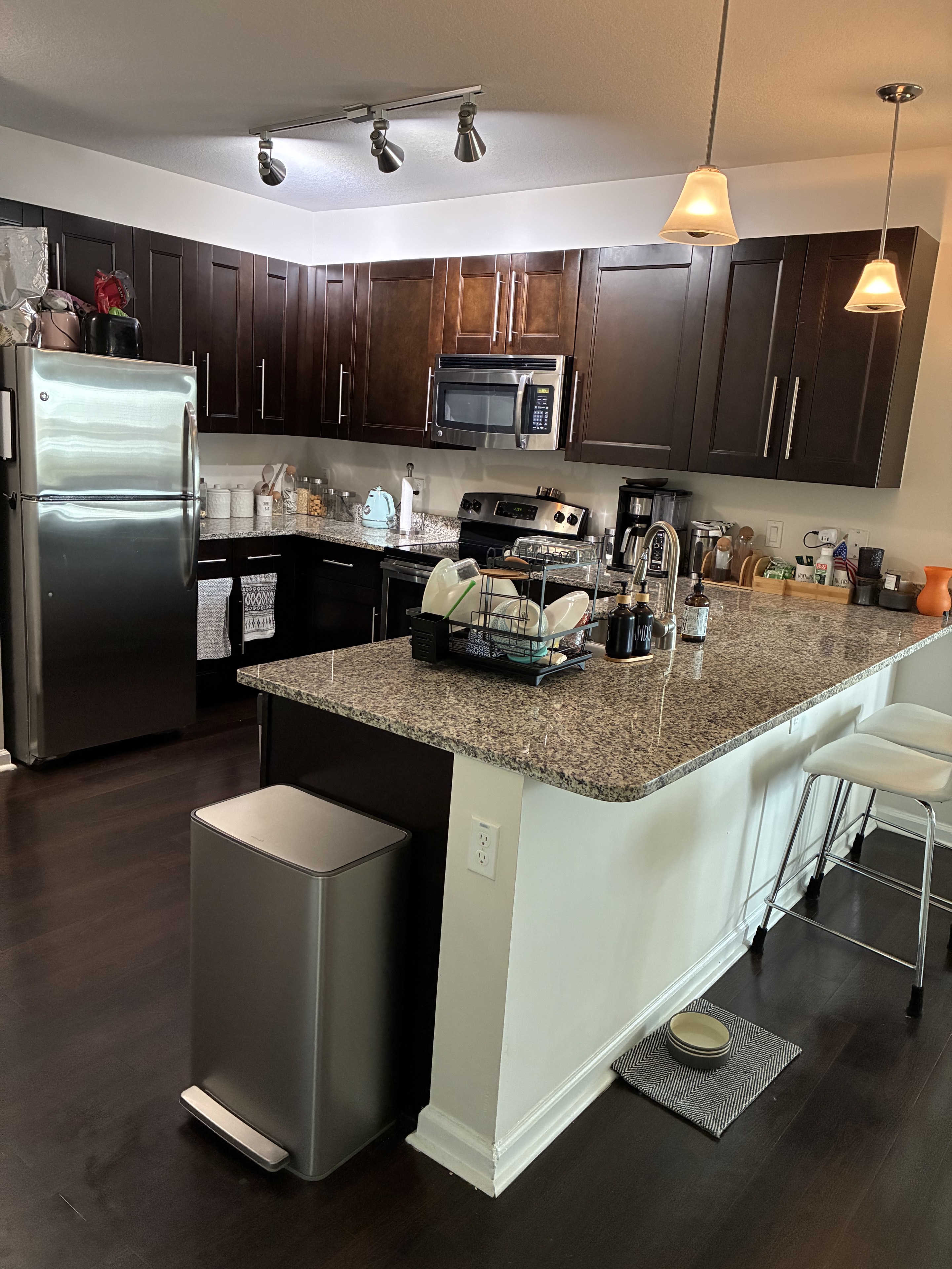 Clean dark kitchen with granite counters, stainless appliances, and island