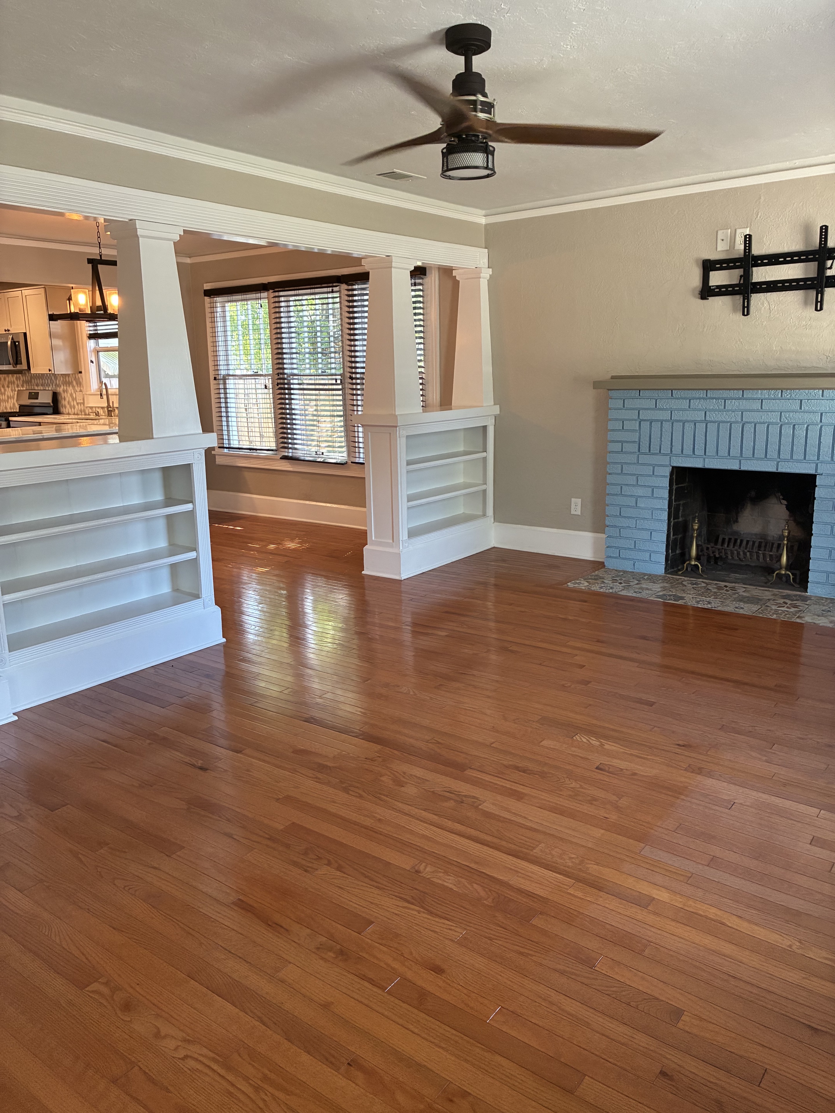 Clean living room with hardwood floors, fireplace, and built-in shelves