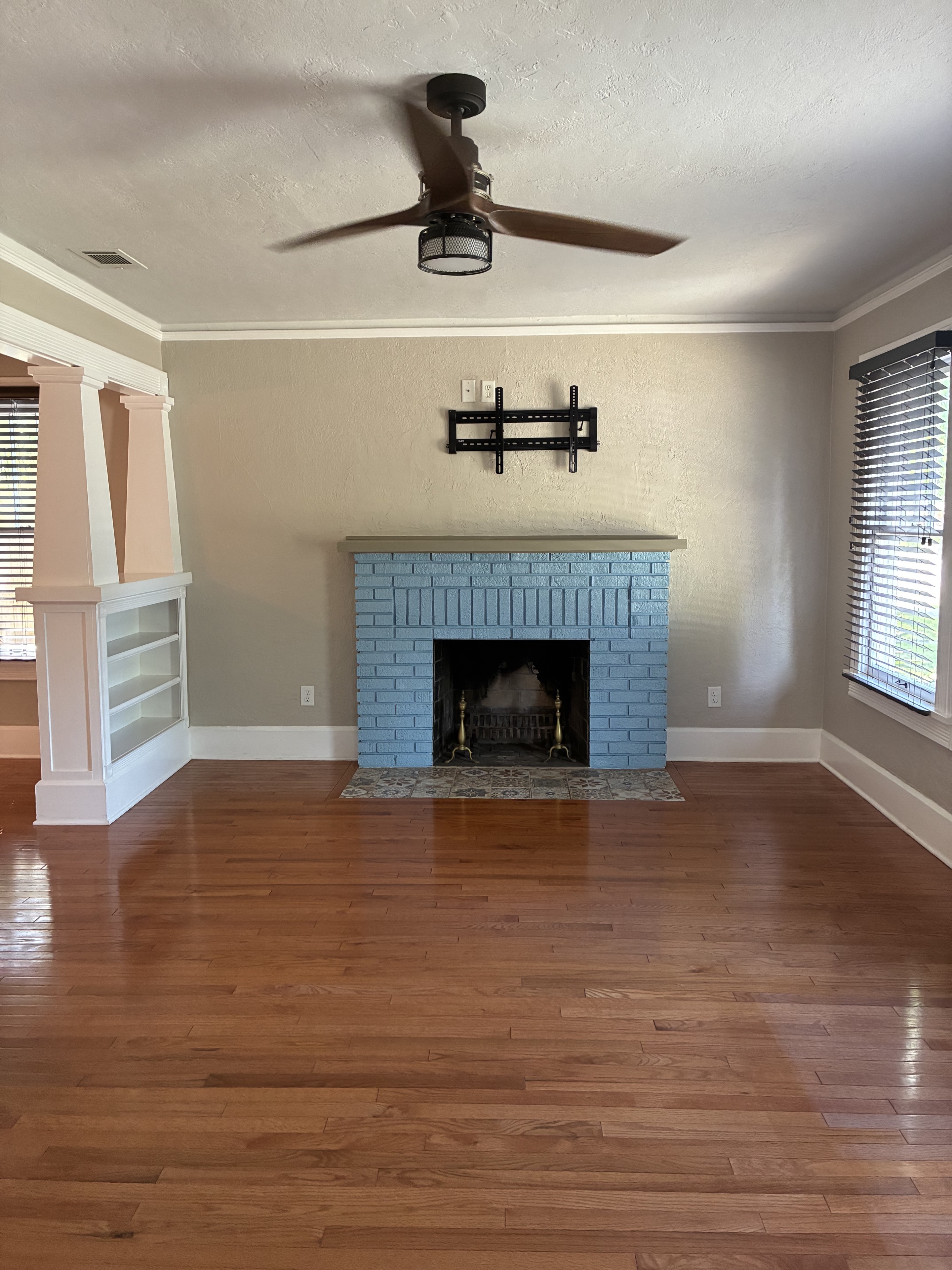 Clean fireplace wall with polished hardwood floor