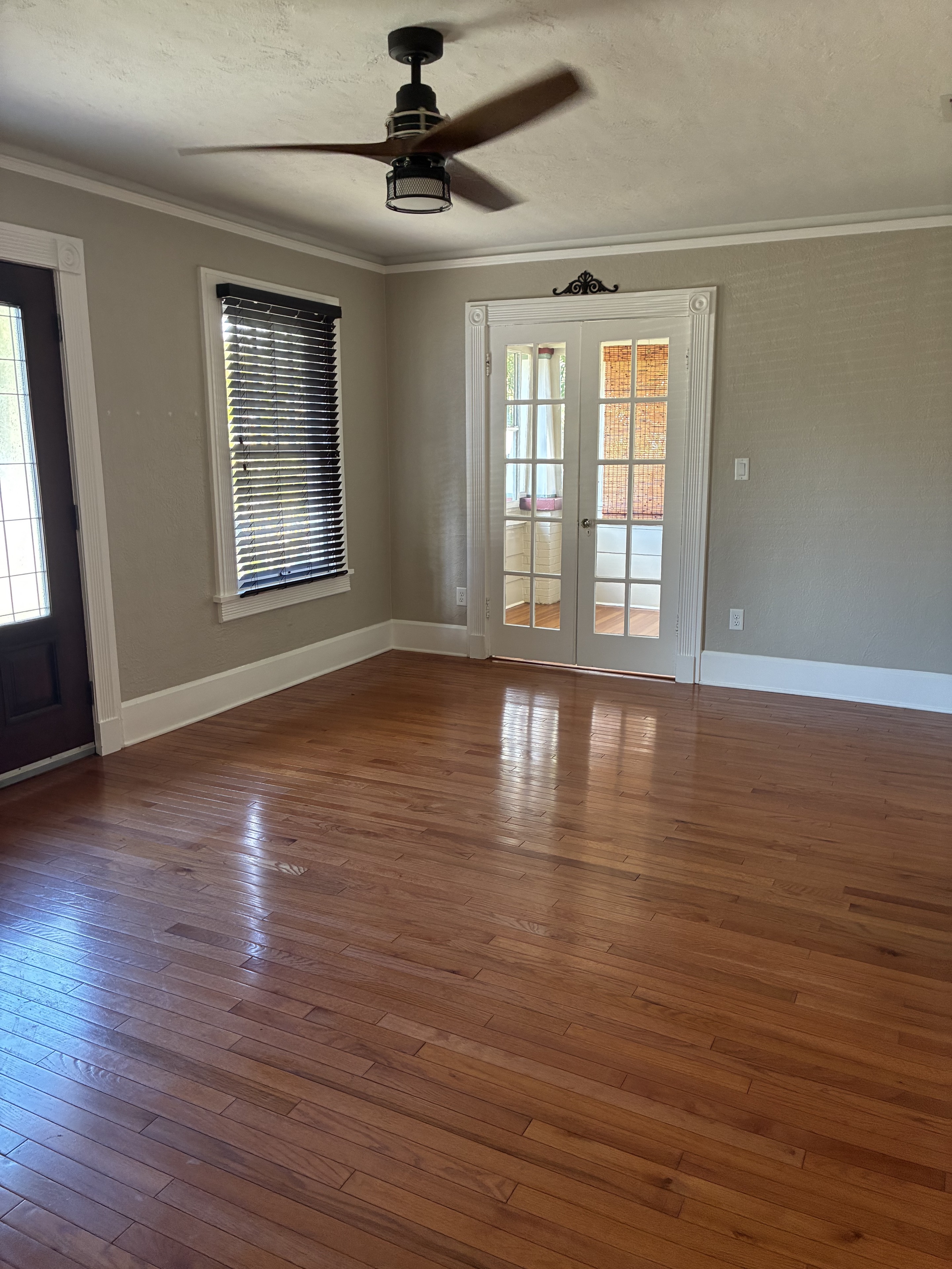 Clean living room with polished hardwood floor and French doors