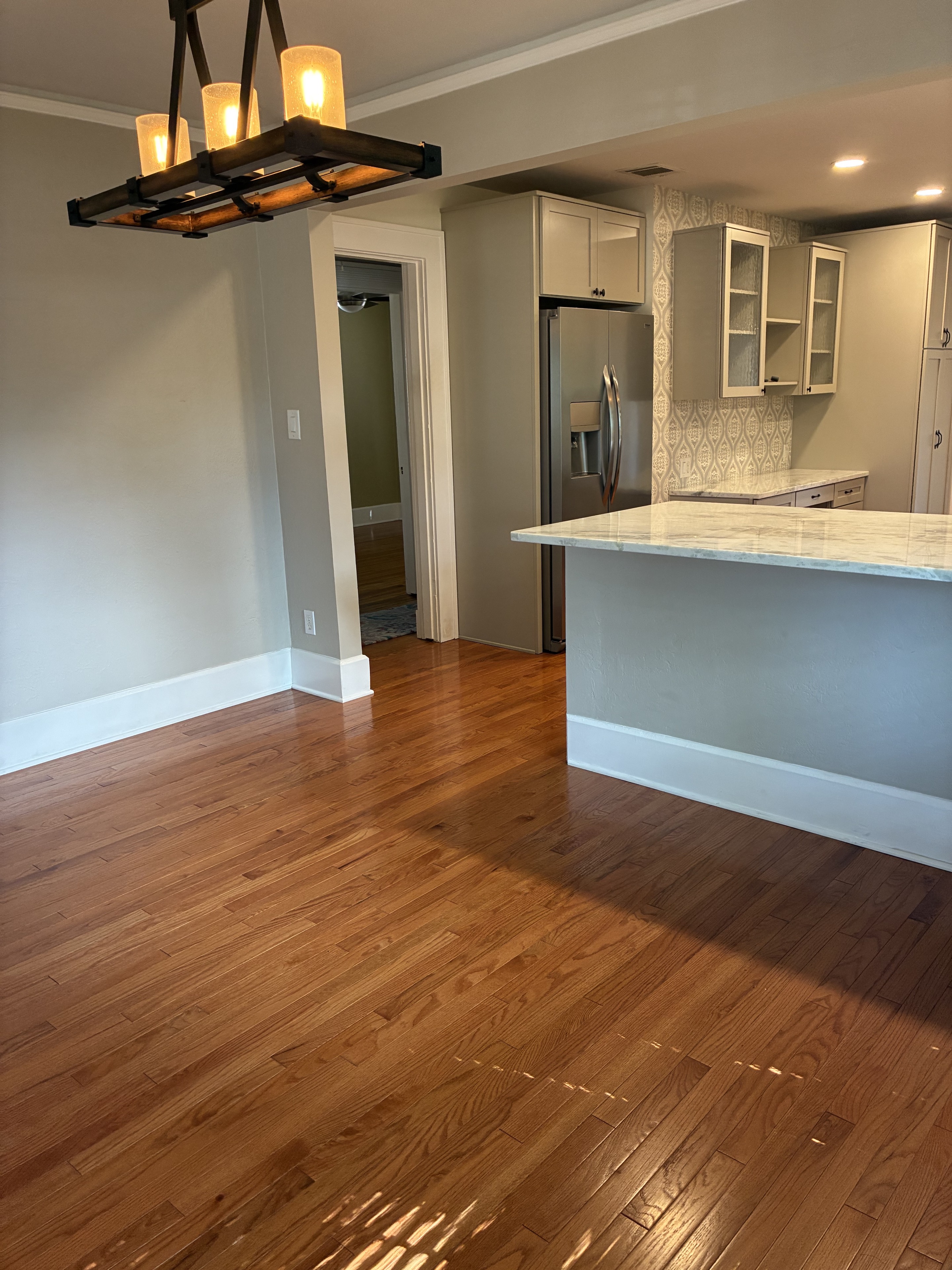 Clean kitchen and dining area with polished hardwood floor
