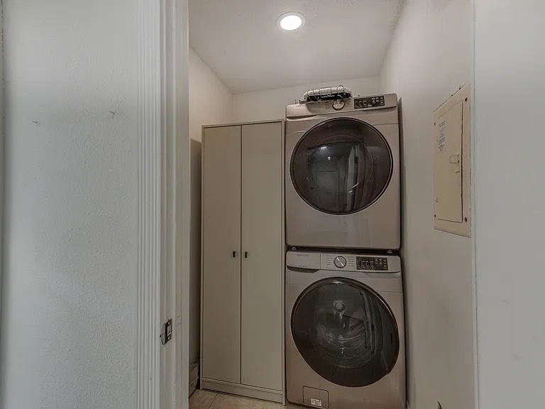 Clean laundry closet with stacked washer and dryer