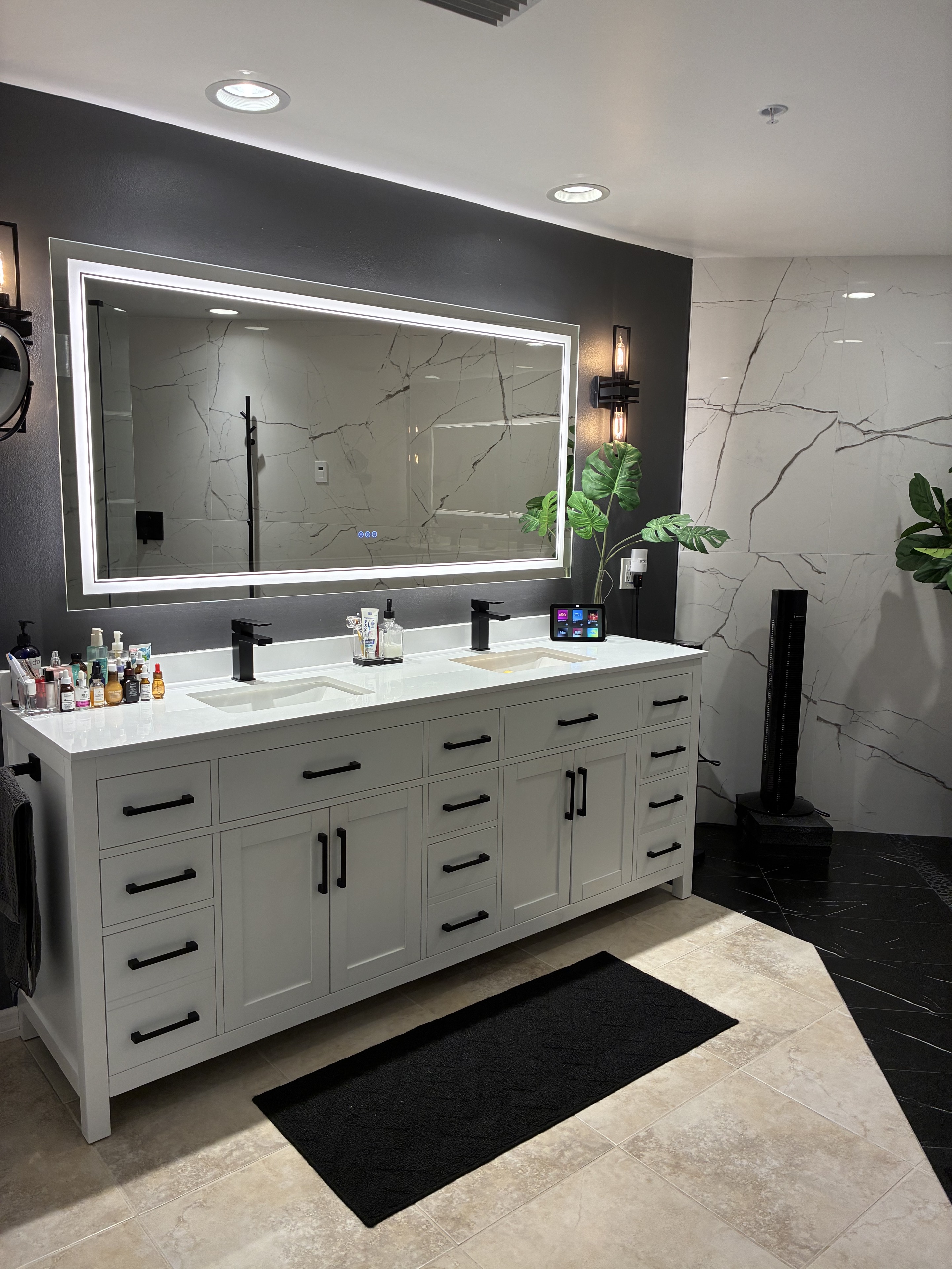 Clean luxury bathroom vanity with illuminated mirror and polished tile