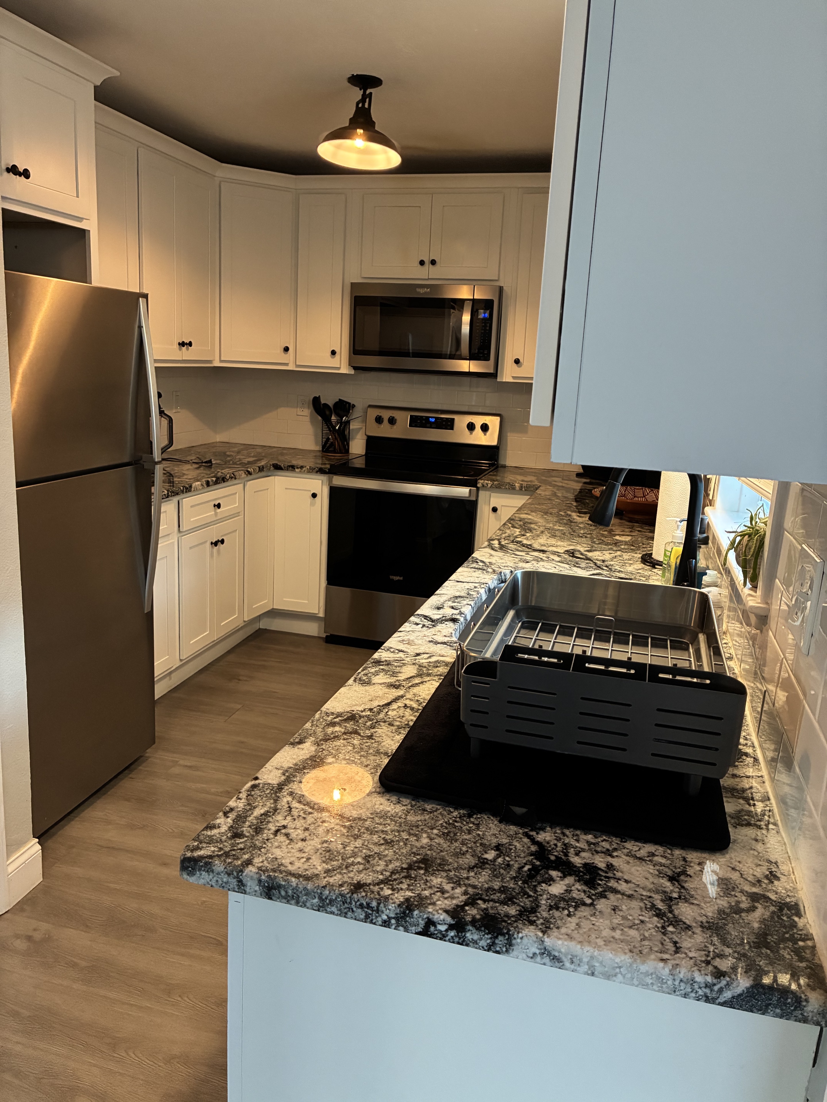 Clean modern kitchen counters, cabinets, sink, and appliances