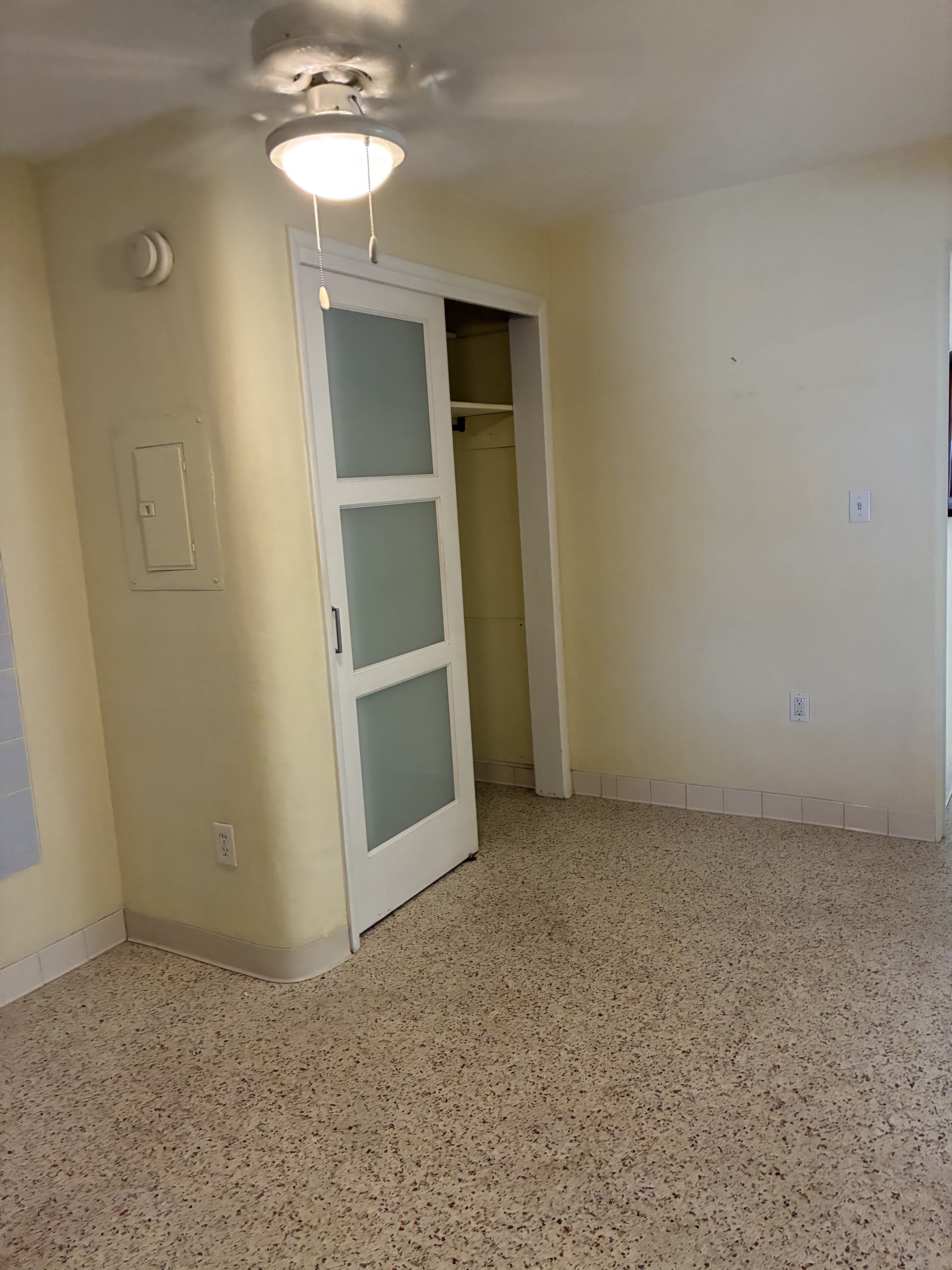 Clean room with open closet door and terrazzo floor