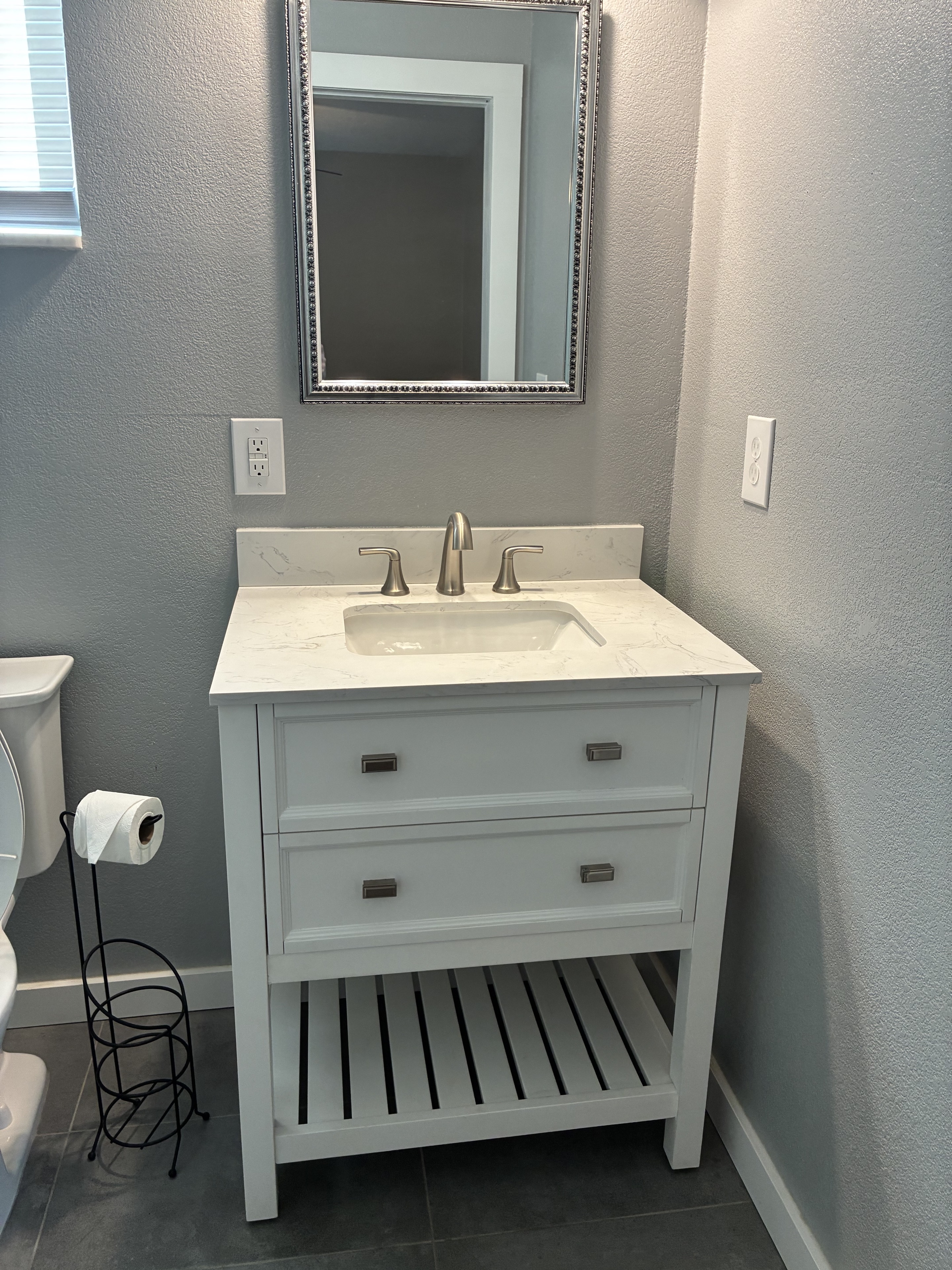 Clean bathroom vanity, mirror, sink, and fixtures