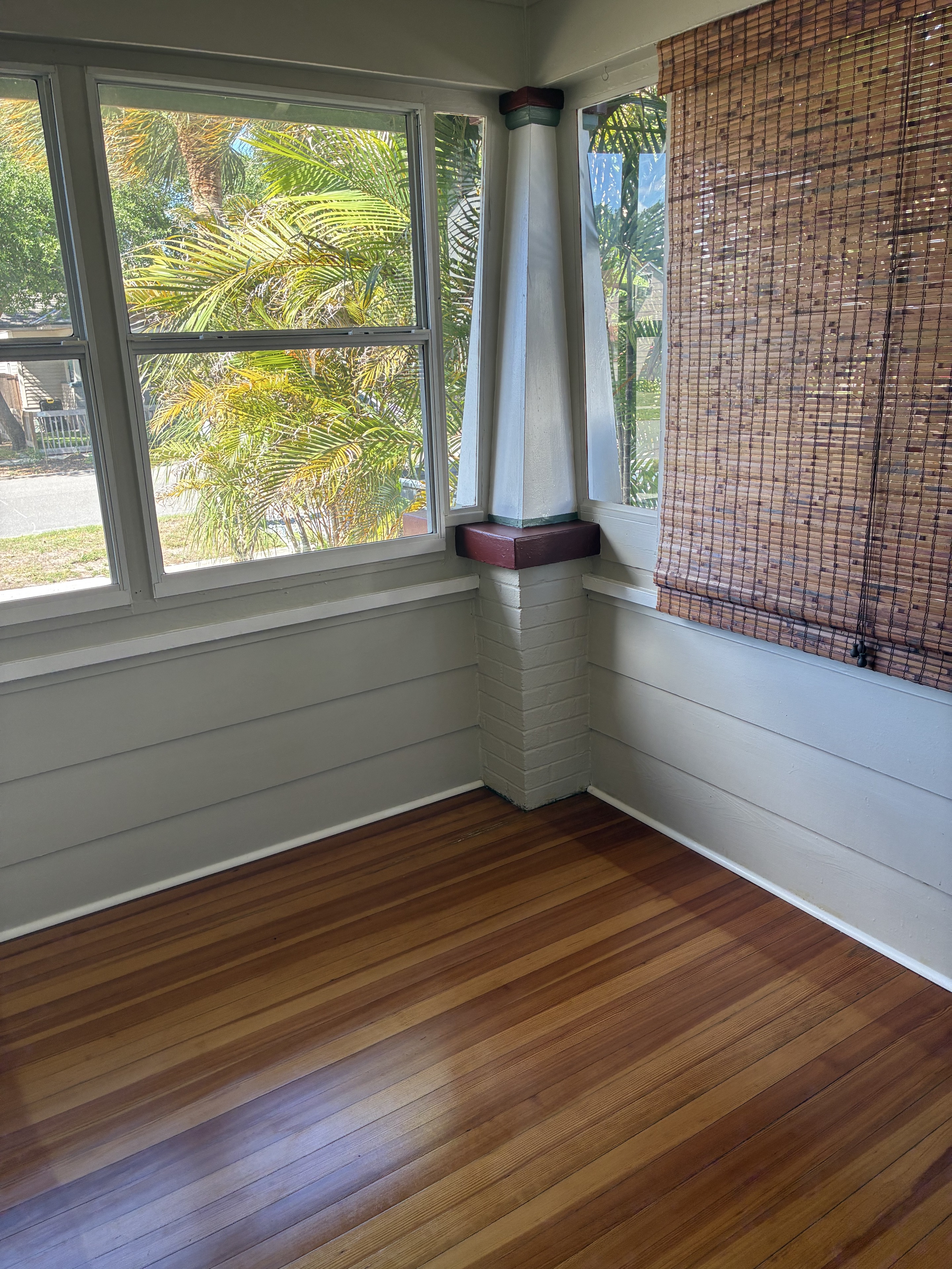 Clean window corner with wood blinds, trim, and hardwood floor
